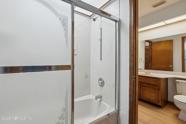 full bathroom featuring hardwood / wood-style floors, vanity, shower / bathtub combination, and toilet