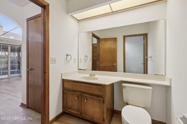 bathroom with wood-type flooring, vanity, and toilet