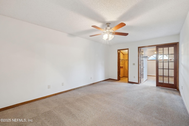 spare room featuring ceiling fan, light colored carpet, and a textured ceiling