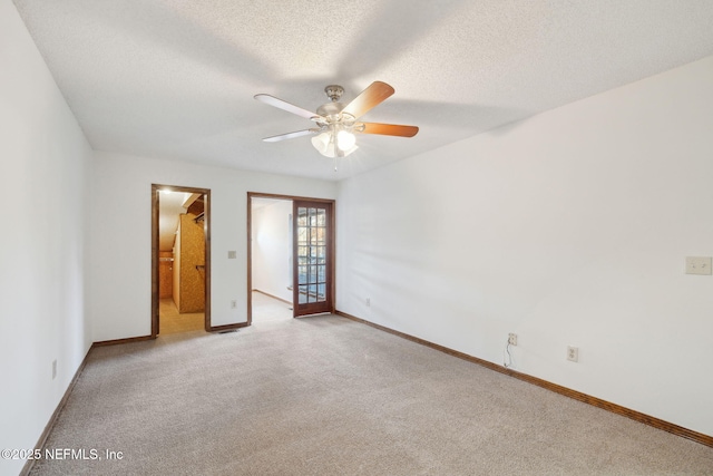 unfurnished bedroom featuring a textured ceiling, ceiling fan, and light carpet