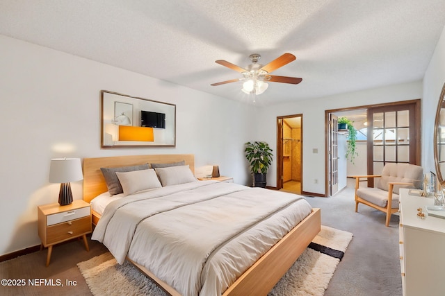 carpeted bedroom featuring a textured ceiling, ensuite bathroom, and ceiling fan