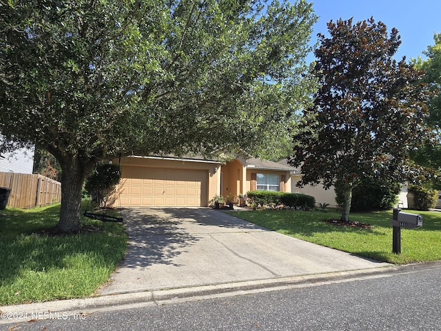 obstructed view of property featuring a garage and a front yard