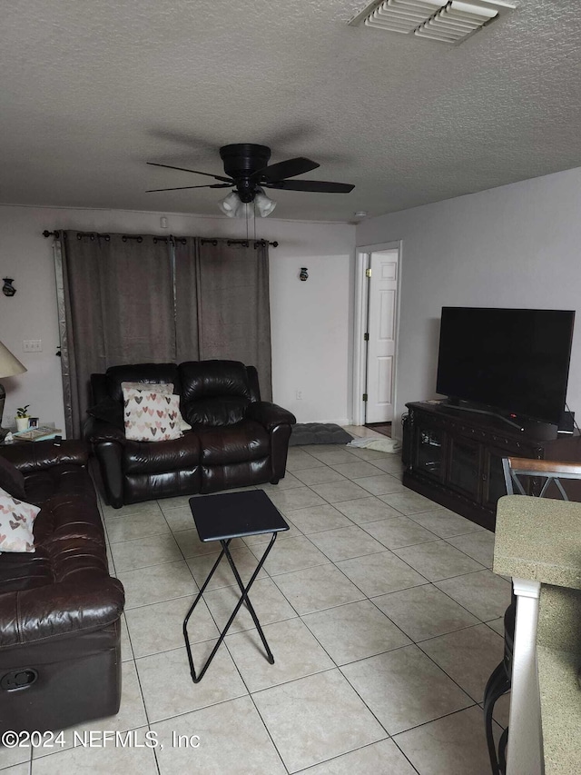 tiled living room featuring ceiling fan and a textured ceiling