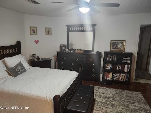 bedroom featuring a textured ceiling, dark hardwood / wood-style floors, and ceiling fan