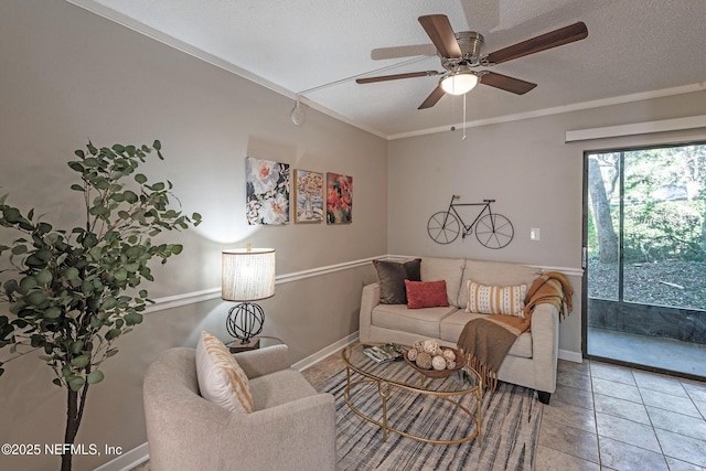 living room featuring ceiling fan, tile patterned flooring, a textured ceiling, and ornamental molding