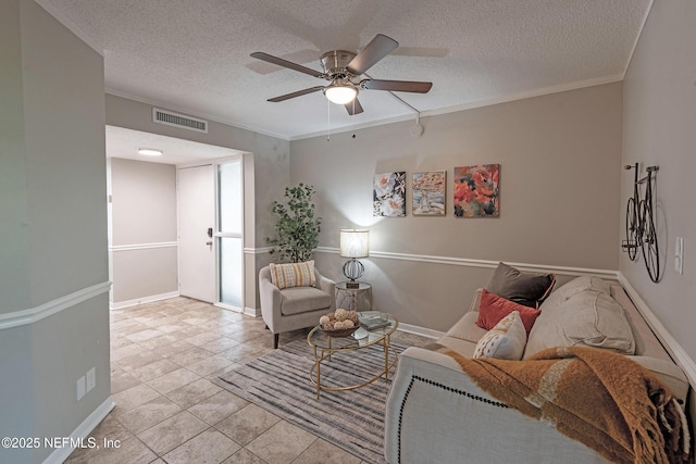 living room featuring a textured ceiling, ceiling fan, ornamental molding, and light tile patterned flooring