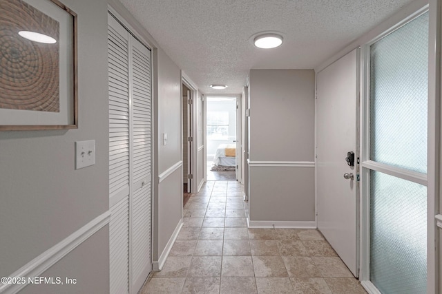 hall featuring a textured ceiling