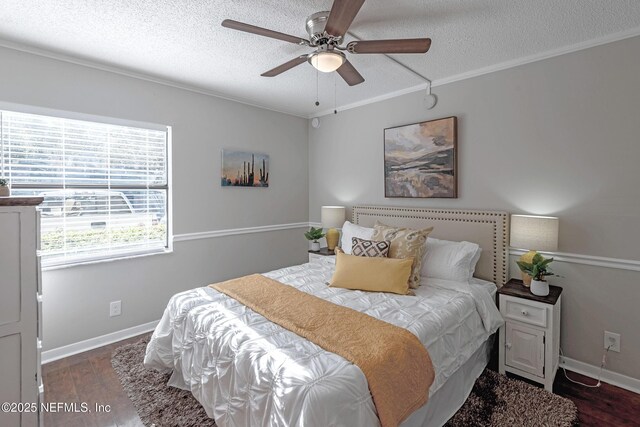 bedroom with ceiling fan, dark hardwood / wood-style floors, crown molding, and a textured ceiling