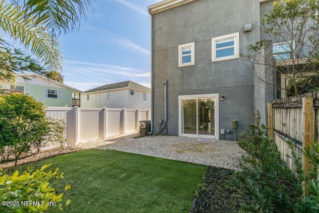 back of house with a yard and a patio