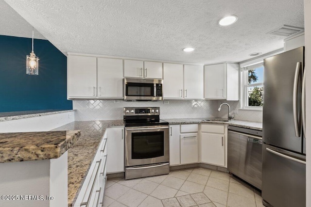 kitchen featuring white cabinetry, sink, stainless steel appliances, and hanging light fixtures