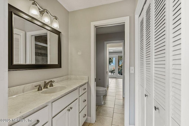 bathroom with vanity, toilet, and tile patterned flooring