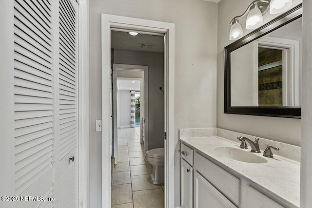 bathroom featuring vanity, tile patterned floors, and toilet