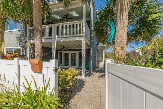 exterior space with ceiling fan, french doors, and a balcony