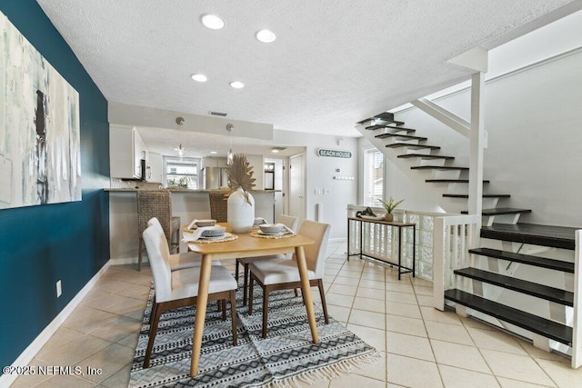 tiled dining room with a textured ceiling