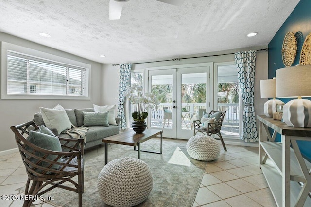 living room with light tile patterned floors, french doors, and a textured ceiling