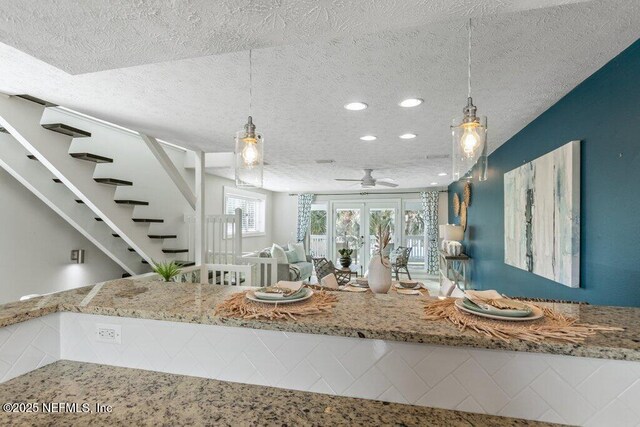 kitchen with hanging light fixtures, french doors, and a textured ceiling