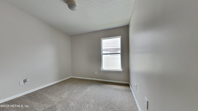 carpeted empty room featuring a textured ceiling