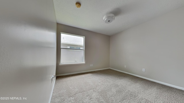 carpeted empty room featuring a textured ceiling