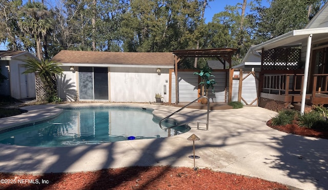 view of pool with a patio and a storage unit