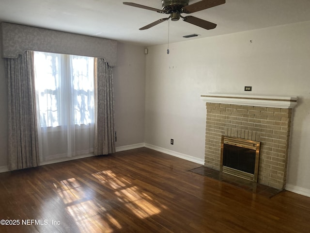 unfurnished living room featuring a fireplace, dark hardwood / wood-style floors, and ceiling fan