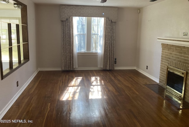 unfurnished living room featuring dark hardwood / wood-style floors, ceiling fan, and a fireplace