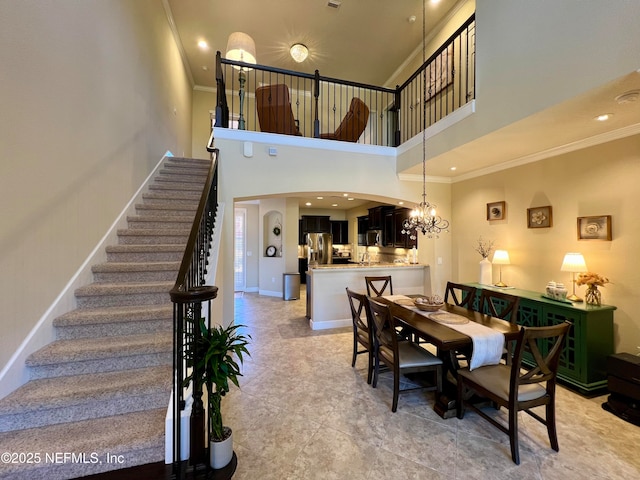 dining space featuring a notable chandelier, ornamental molding, and a high ceiling