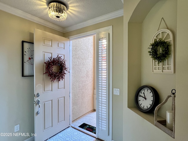 entryway with a textured ceiling and ornamental molding