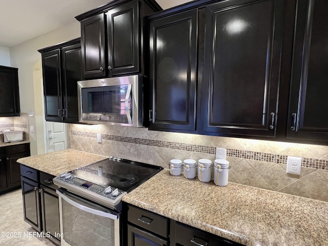 kitchen featuring light tile patterned floors, backsplash, and stainless steel appliances