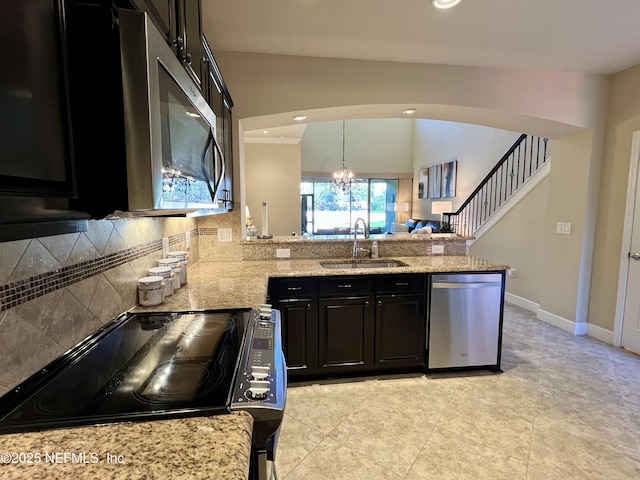 kitchen featuring an inviting chandelier, sink, hanging light fixtures, kitchen peninsula, and stainless steel appliances