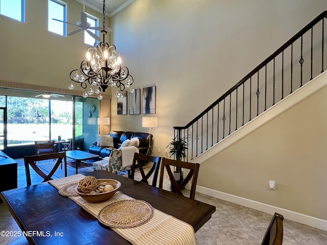 dining area featuring a high ceiling, ceiling fan with notable chandelier, and ornamental molding