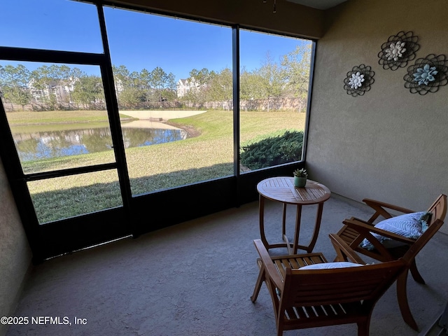 sunroom featuring a water view