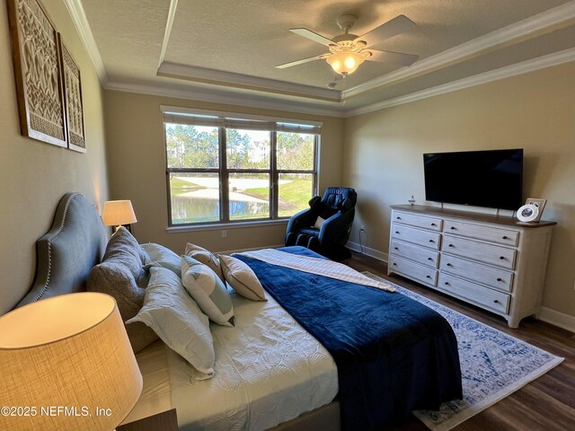 bedroom with a tray ceiling, crown molding, ceiling fan, and dark hardwood / wood-style floors