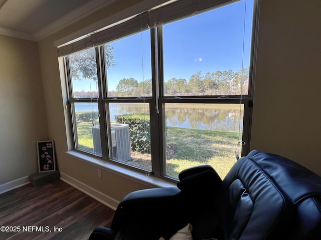 interior space featuring a wealth of natural light, dark hardwood / wood-style flooring, a water view, and ornamental molding