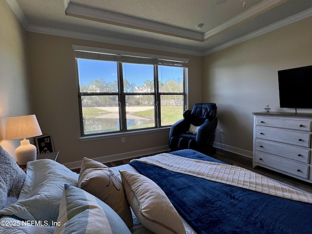 bedroom featuring hardwood / wood-style floors, a raised ceiling, and crown molding