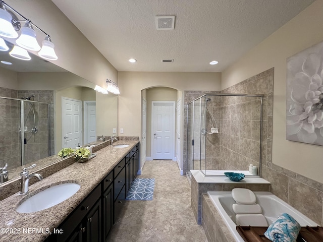 bathroom featuring vanity, a textured ceiling, and independent shower and bath