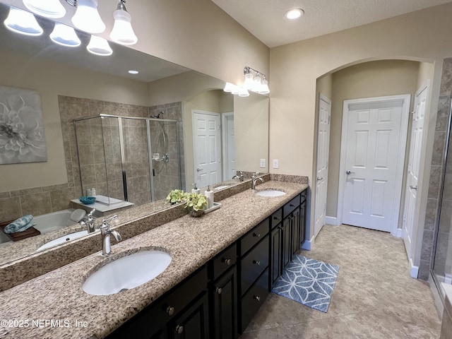 bathroom featuring tile patterned flooring, shower with separate bathtub, and vanity