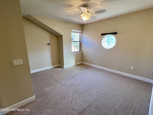 empty room with ceiling fan, carpet floors, and a textured ceiling