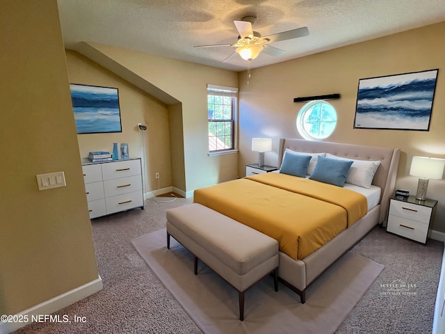 bedroom with a textured ceiling, light colored carpet, and ceiling fan