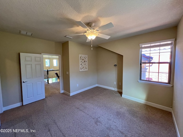 carpeted empty room with ceiling fan and a textured ceiling