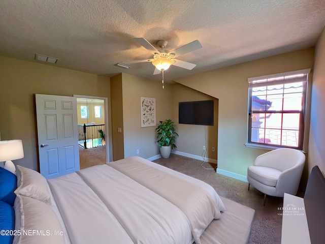 carpeted bedroom with ceiling fan and a textured ceiling