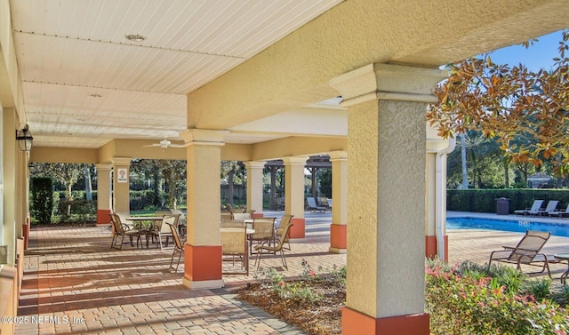 view of patio / terrace with ceiling fan and a community pool