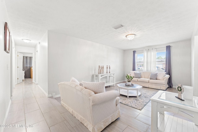 living room with a textured ceiling and light tile patterned flooring