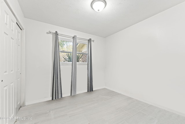 unfurnished room featuring a textured ceiling