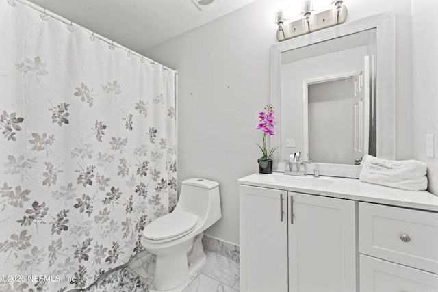 bathroom featuring vanity, a textured ceiling, and toilet