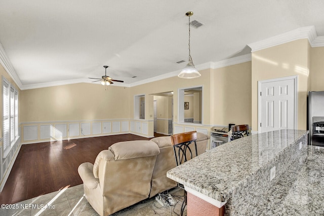 living room with ceiling fan and ornamental molding