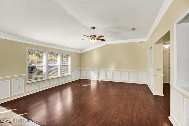 empty room featuring ceiling fan, hardwood / wood-style floors, vaulted ceiling, and ornamental molding