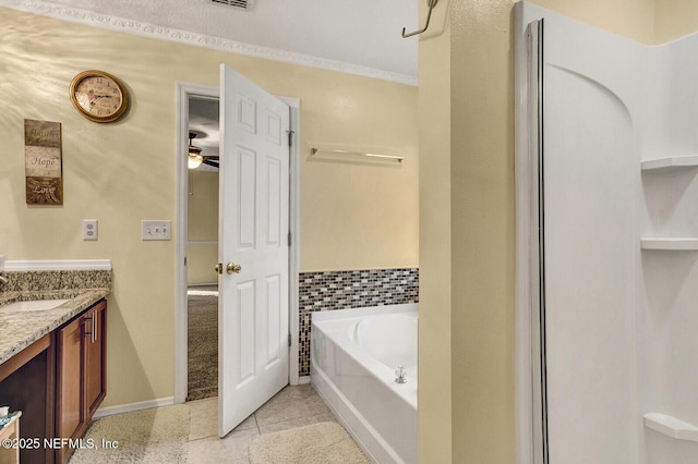 bathroom with ceiling fan, a tub to relax in, tile patterned floors, crown molding, and vanity