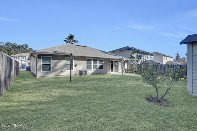 rear view of property featuring central air condition unit and a yard