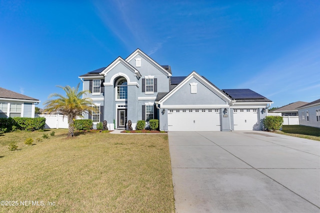 view of property with a front lawn, a garage, and solar panels