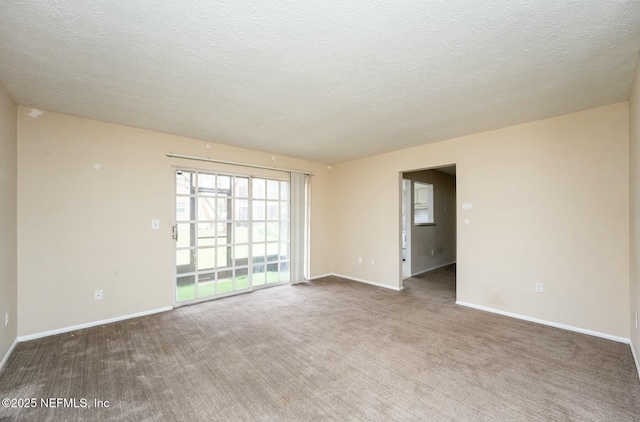 carpeted spare room featuring a textured ceiling